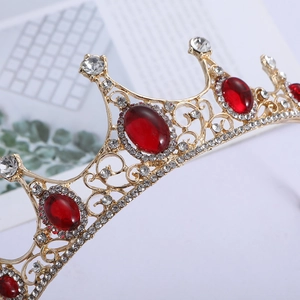 Detailed view of Baroque crown with red rhinestones and gold hollow-out craftsmanship