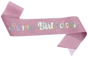 Detail of pink glitter fabric sash with holographic It's my Birthday silver lettering