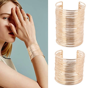 Close-up of a wide gold multi-layer wire cuff bracelet showing a metallic braided texture
