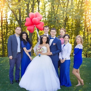 Outdoor wedding set with bride in white ball gown, blue dresses, and heart balloon