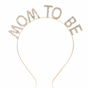 Close-up of MOM TO BE gold headband with sparkly rhinestones for baby shower party