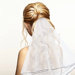 Detailed back view of a white double-layer bridal veil with satin ribbon edge on a model