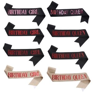 Detailed view of Birthday Girl and Queen sashes in glitter fabric with gold foil lettering