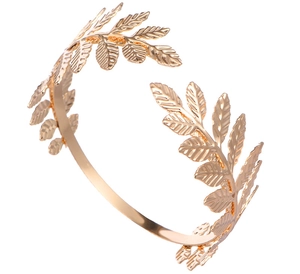 Detail of a golden laurel leaf arm cuff with textured foliage in Greek bohemian style