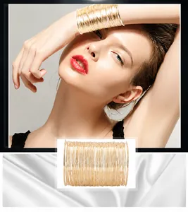 Exquisite wide multi-layered golden wire cuff bracelet shown on wrist and white silk