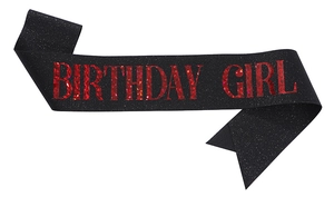 Detail of black glitter fabric Birthday Girl sash with red metallic foil lettering