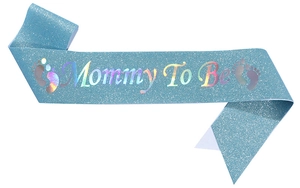 Macro detail of light blue glitter sash with Mommy To Be laser print and baby footprints