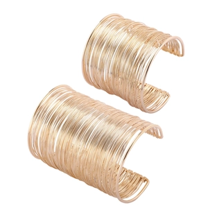 Close-up of gold layered open cuff bracelets featuring multi-strand wire metal design
