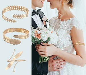 Detailed view of three gold baroque leaf and feather arm cuffs with adjustable metal design