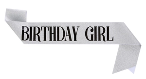 Dettaglio di una fascia glitterata argento con scritta nera Birthday Girl per feste