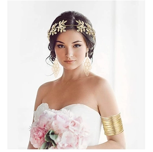 Detailed view of wide hollow gold arm cuff on model with bridal jewelry set