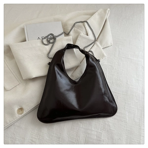 Detailed top-down view of a glossy hobo bag featuring a metallic silver chain strap