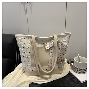 Détail du cabas blanc cassé avec texture plissée et décoration élégante en foulard