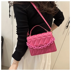 Pink quilted square crossbody bag with chunky chain strap worn by a model