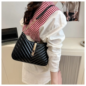 Détail du sac à bandoulière plissé noir avec chaîne dorée et fermoir métallique