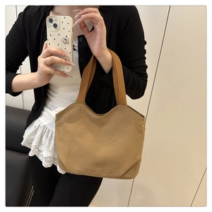 Detail of tan canvas tote bag showing thick texture and brown woven strap handles