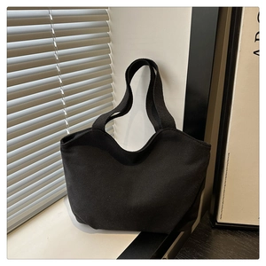 Minimalist black canvas tote bag shown in soft window light with striped shadows
