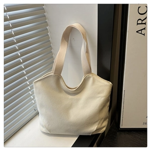 Close-up of cream white canvas tote bag with textured fabric and minimalist handle details