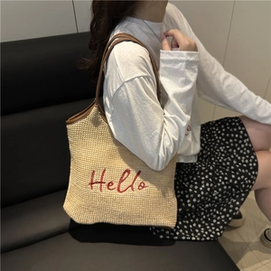 Large woven straw beach tote bag with red Hello embroidery and brown leather shoulder straps