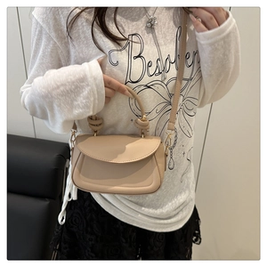Close-up of beige PU leather crossbody bag featuring subtle gold-tone hardware and stitching