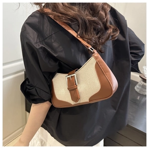 Detail view of vintage canvas underarm bag with brown leather trim and silver buckle