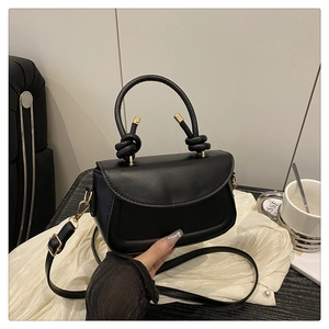 Detailed macro view of the black PU leather handbag with elegant golden hardware accents