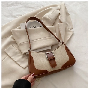 Detail of linen and brown leather patchwork bag with a silver metal buckle and strap