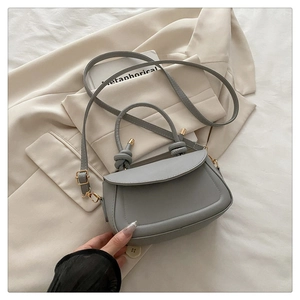 Detailed top view of a grey matte leather handbag with unique knotted handle and gold hardware