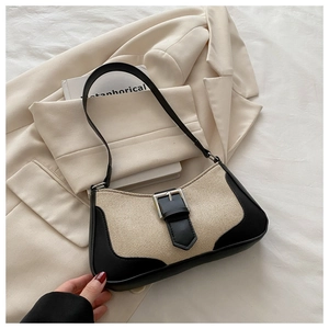 Detail of a chic linen shoulder bag with black leather trim and silver metal buckle