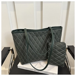Détail d'un ensemble cabas matelassé vert foncé avec coutures blanches et pochette assortie