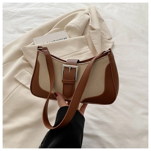 Close-up of linen and brown leather patchwork shoulder bag with silver buckle