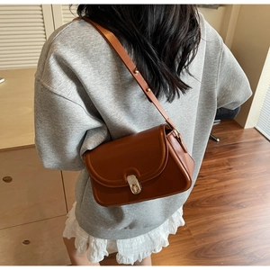 Vue arrière du sac bandoulière en cuir marron avec fermoir rotatif en argenté
