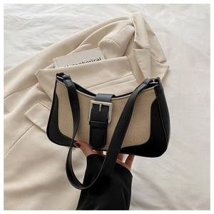 Detail of linen stitching and silver buckle on the contrast shoulder bag