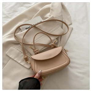 Detailed view of beige PU leather mini bag with knotted handle on a blazer