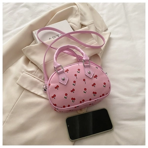 Detailansicht der rosa Handtasche mit Kirschmuster, Doppelgriffen und Silbernieten
