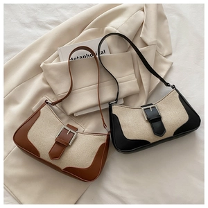Detail of canvas and leather patchwork bags with decorative metal buckle in brown and black