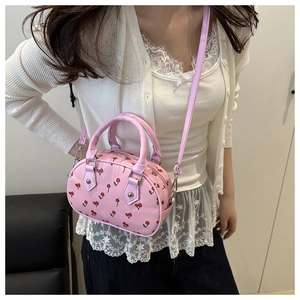Detail der rosa PU-Handtasche mit Kirschdrucken und abnehmbarem Schultergurt
