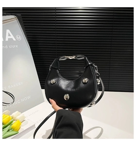 Détails du sac croissant noir avec rivets argentés et bandoulière amovible