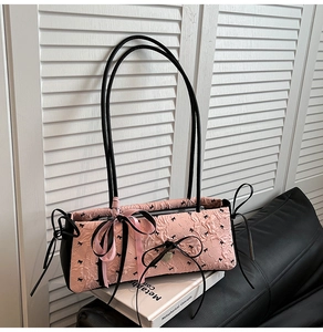 Detail der rosa Seersucker-Tasche mit schwarzen Schleifen und Herz-Metallanhänger