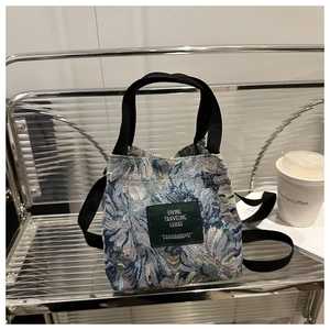 Detail of vintage floral jacquard tote bag with blue sunflower pattern on a display shelf