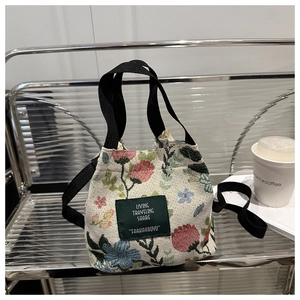 Detail of floral canvas tote bag with woven straps and vintage jacquard flower pattern