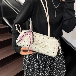 Borsa a spalla bianca con fiocchi texture a rilievo e ciondolo a cuore indossata