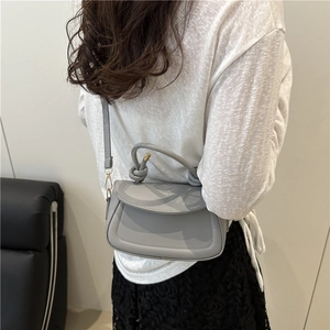 Chic grey underarm bag with knotted handle and sleek shoulder strap for women