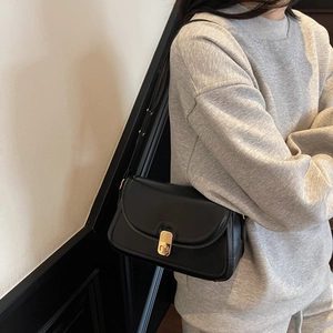 Sac à bandoulière minimaliste en cuir noir mat avec boucle dorée pour femmes