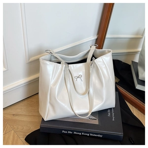 Détail du sac fourre-tout en cuir PU blanc avec nœud en métal argenté et plis