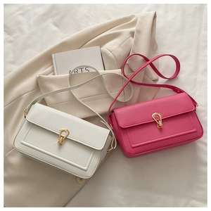 Vue détaillée des sacs à bandoulière blancs et magenta avec boucles dorées en forme de U