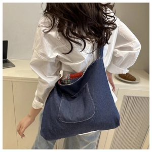 Détail du sac cabas en denim bleu montrant la doublure en patchwork floral et à carreaux