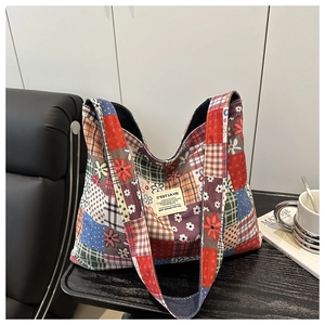 Vue détaillée du cabas en toile avec patchwork floral et à carreaux et étiquette tissée