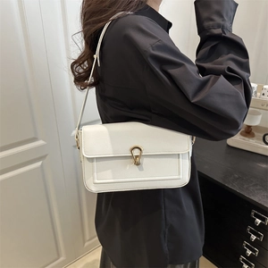 Sac à bandoulière en cuir blanc chic avec boucle fer à cheval dorée sur mannequin