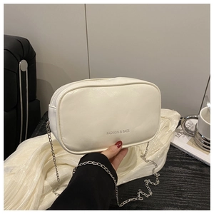 Gros plan du sac oreiller en PU blanc texturé avec chaîne argentée et logo